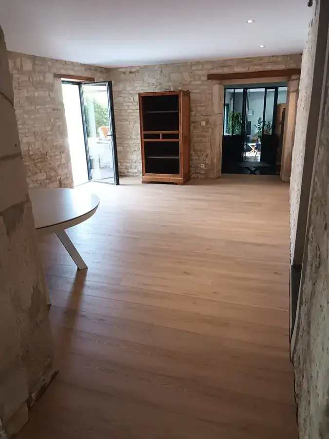 Exemple d'ambiance intérieure avec mur en pierre, parquet clair et finitions propres